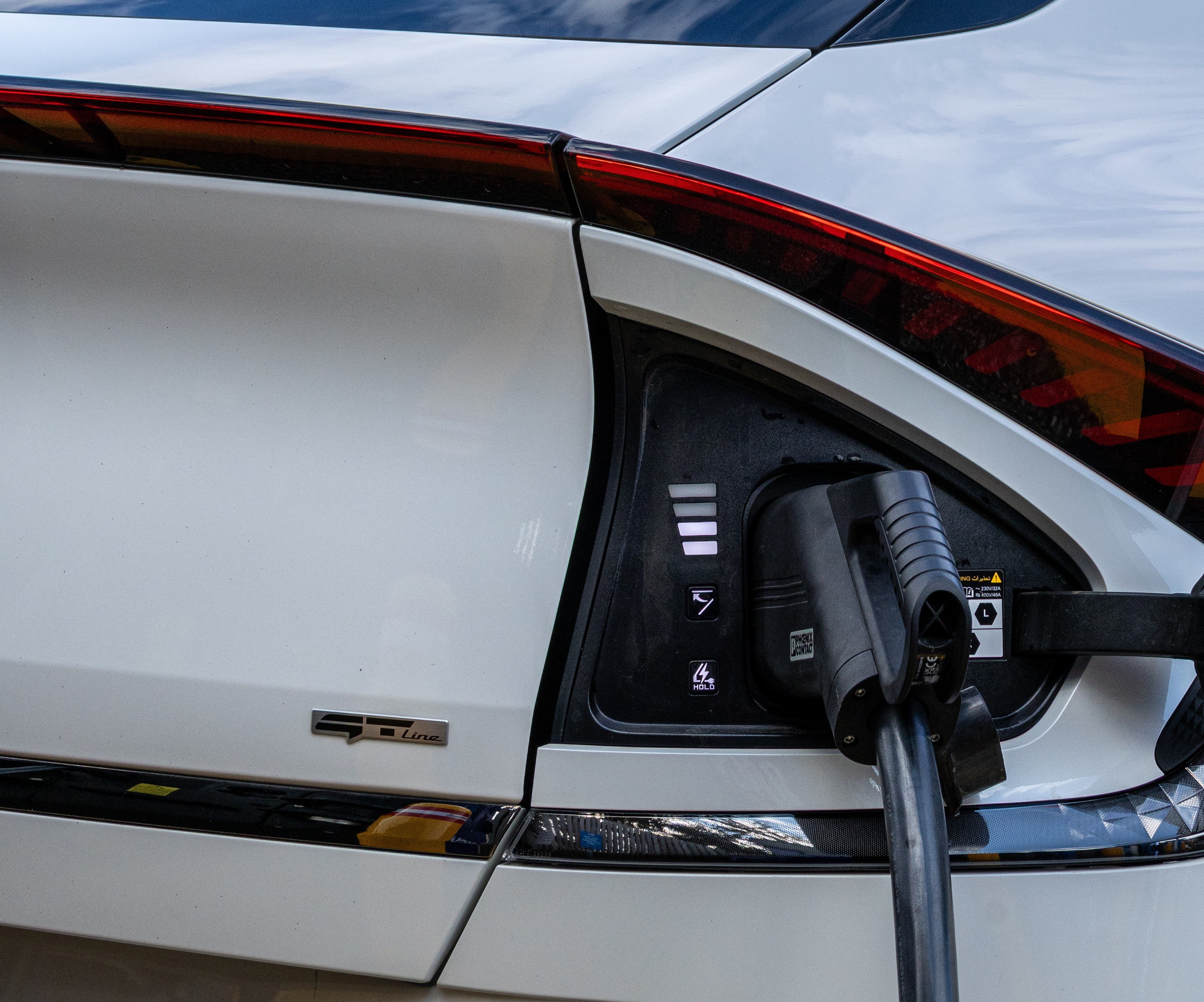 Photo of an electric vehicle with charger connected.  