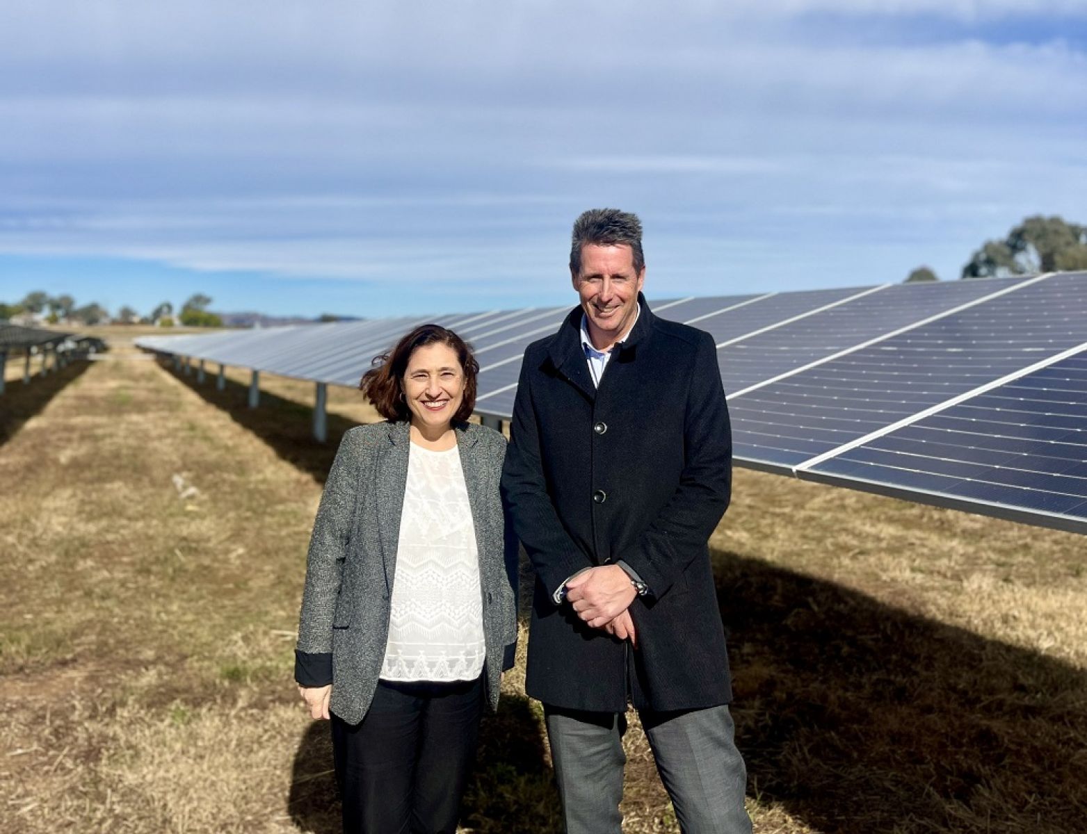 Minister for Energy and Resource Lily D'Ambrosio with Pacific Partnerships executive general manager Graham Whitson in a field of solar panels at the opening of the Glenrowan Solar Farm