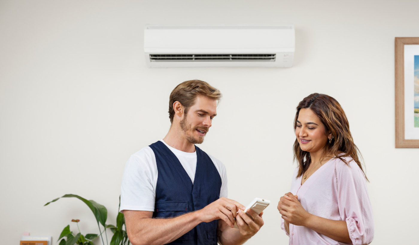 Technician showing a person remote control for air con