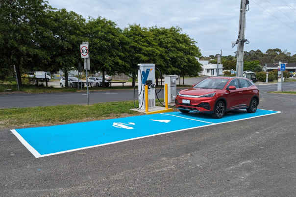 Photo of a red electric vehicle parked at a charging station