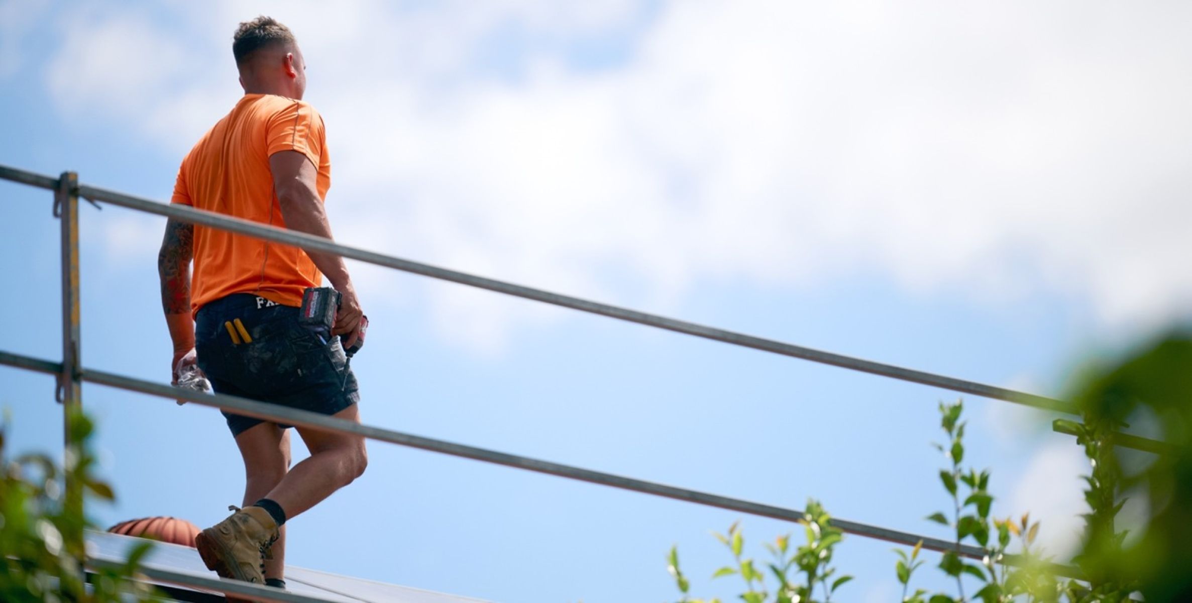 Person in safety gear on roof with edge protection