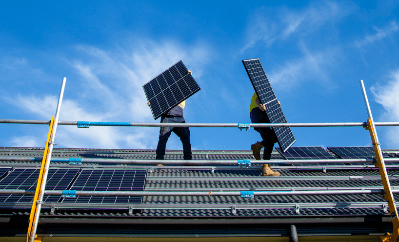 People installing solar panels on roof  