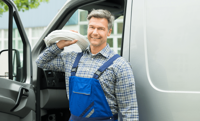 Person holding equipment next to van  