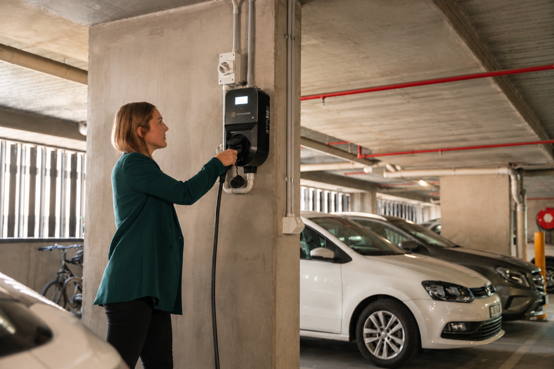 A person plugging their EV into a Level 2 charger