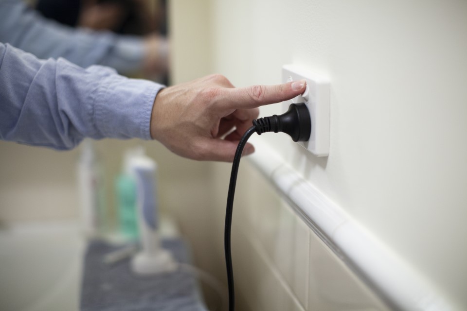 person flicking on a power switch