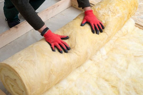 person rolling out insulation