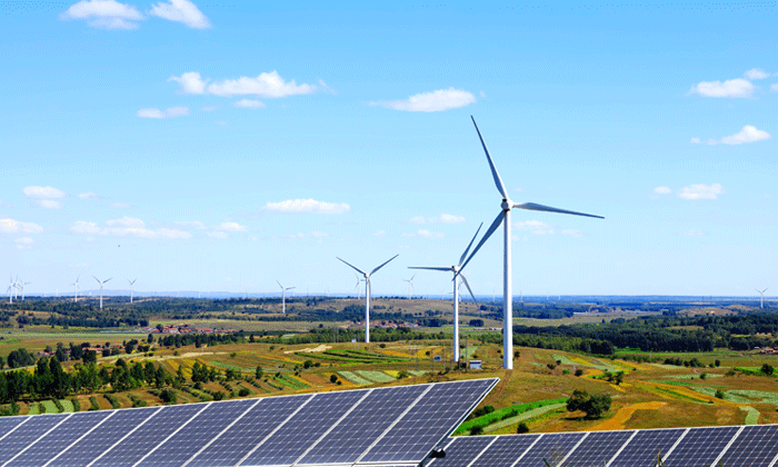 Solar panels and wind turbines in a field  